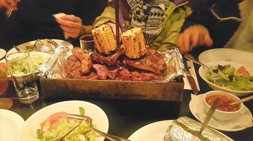 Gemengde grillschaal met vlees en gegrilde maiskolf