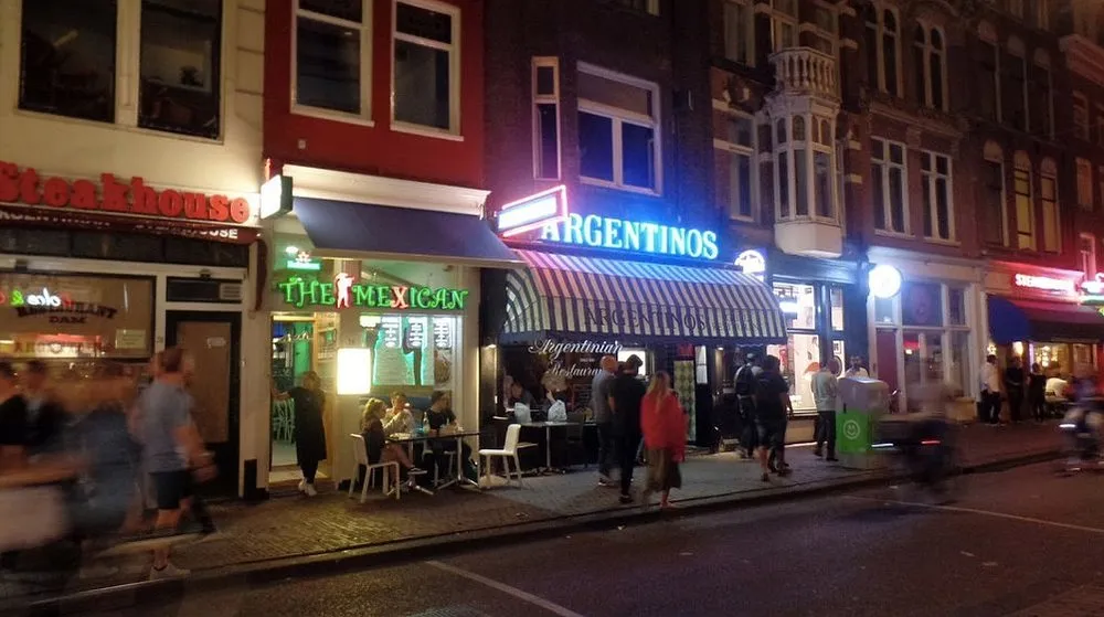 Neonreclame van Argentinos Grill op de Damstraat bij avond