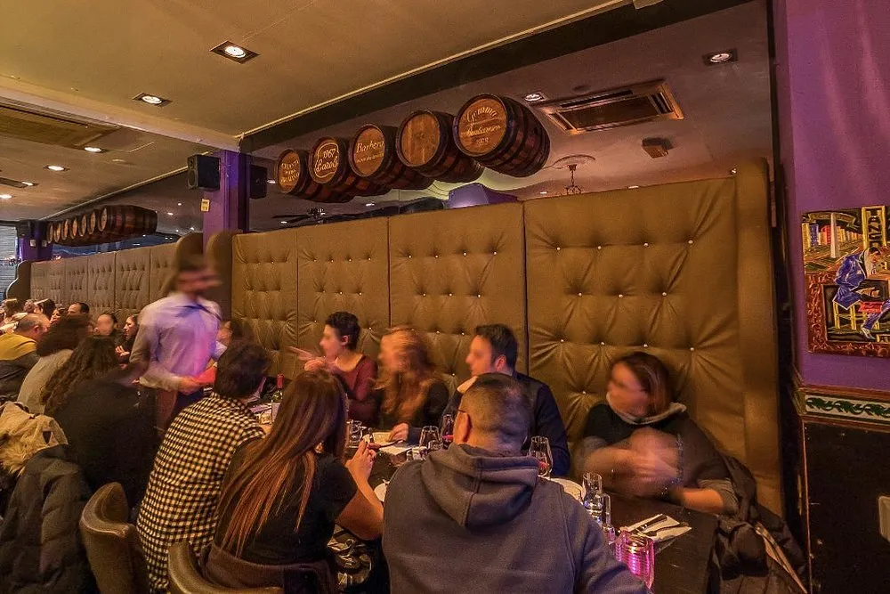 Volle eetzaal van Argentinos Grill, met wijnvaten aan de wand