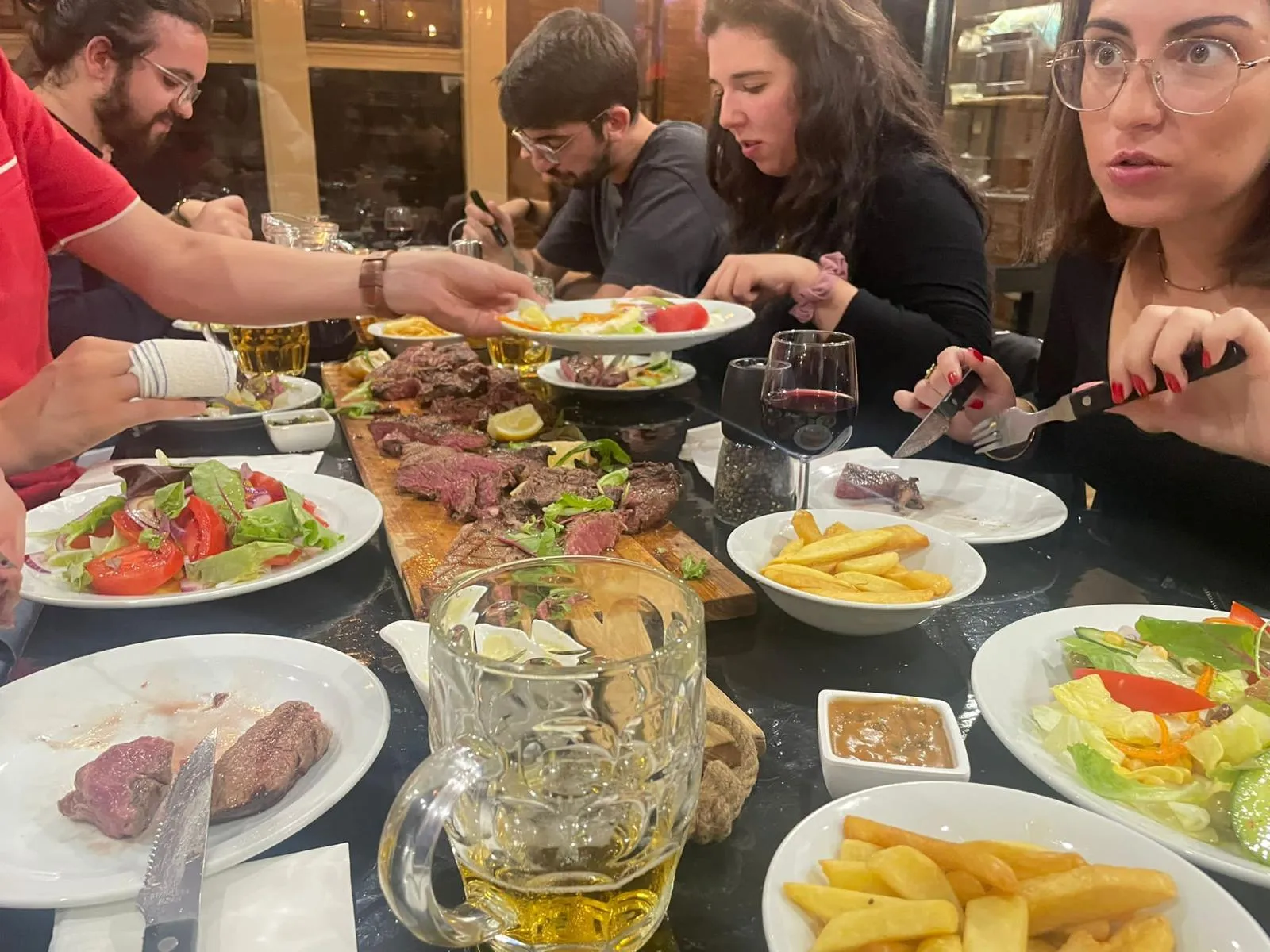 Gedekte tafel met steaks friet salade en wijn bij Carne Argentina