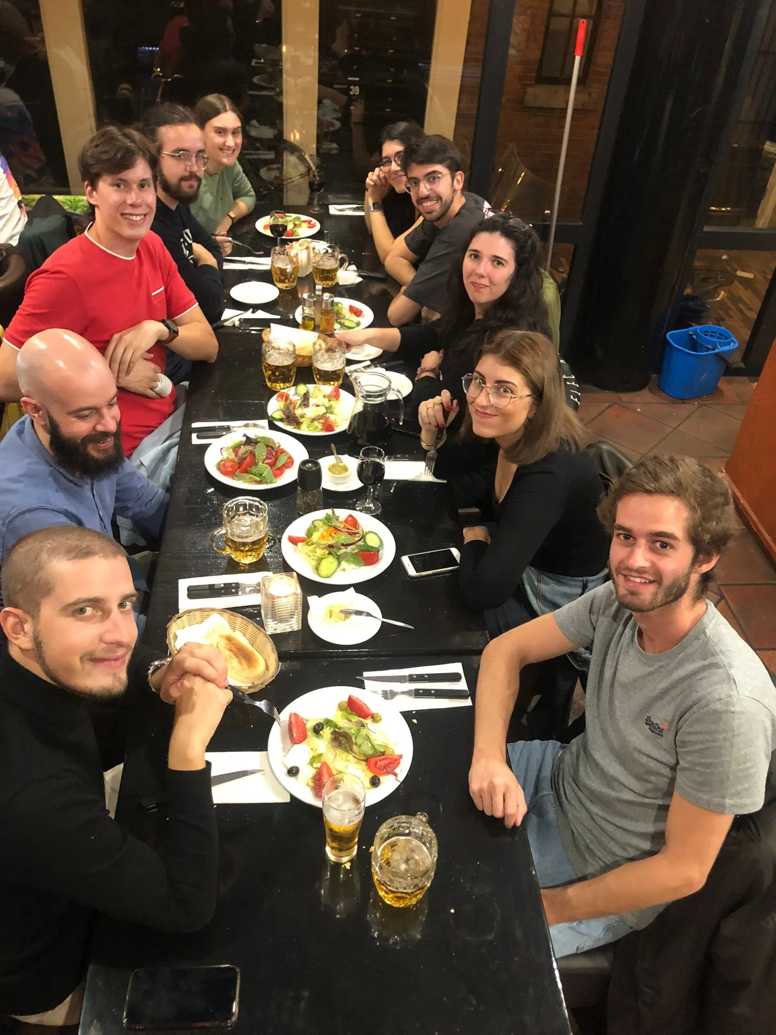 Groot gezelschap aan de lange tafel in het restaurant aan de Damstraat