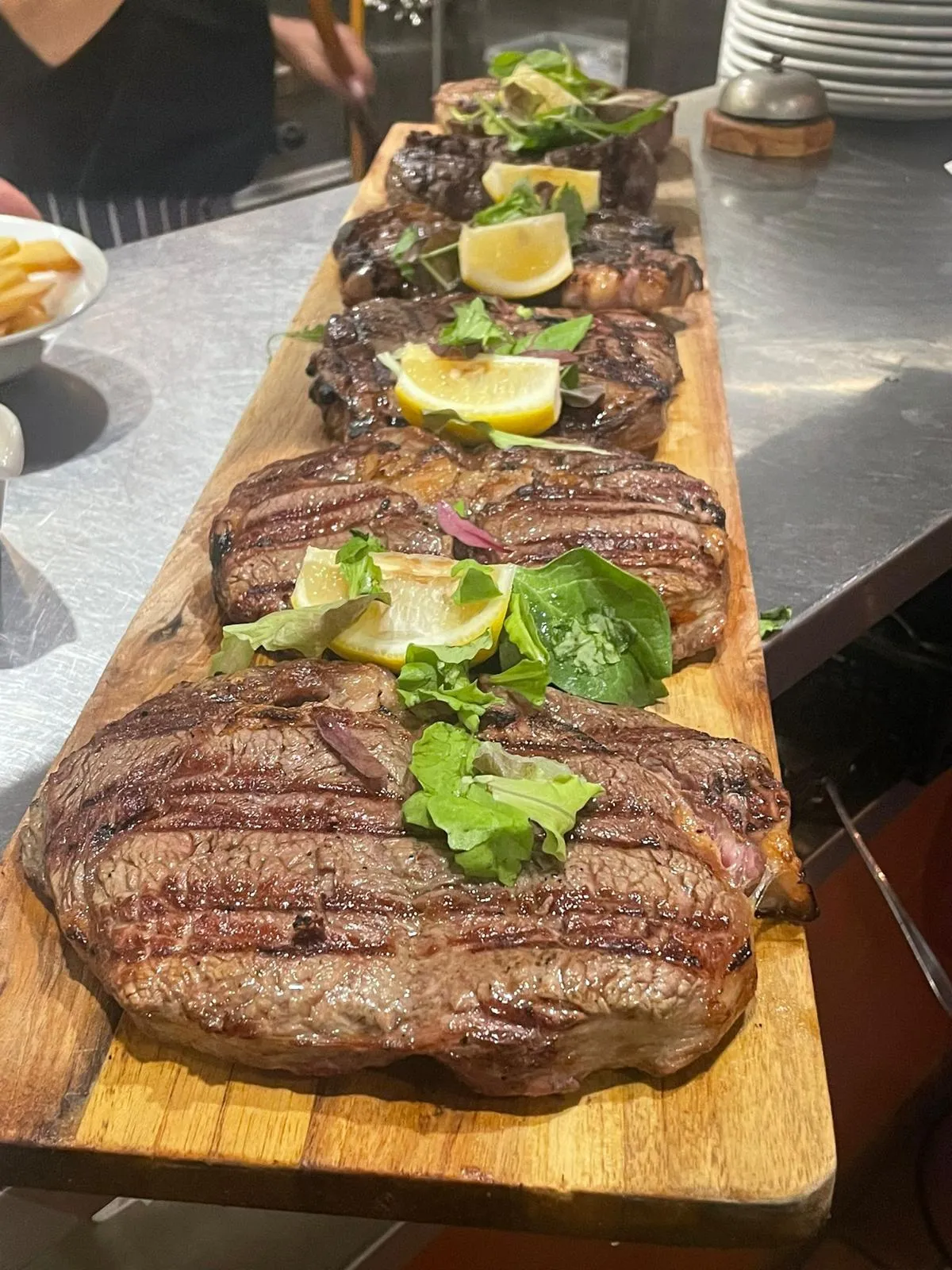 Plank met gegrilde steaks en citroen klaar om te serveren