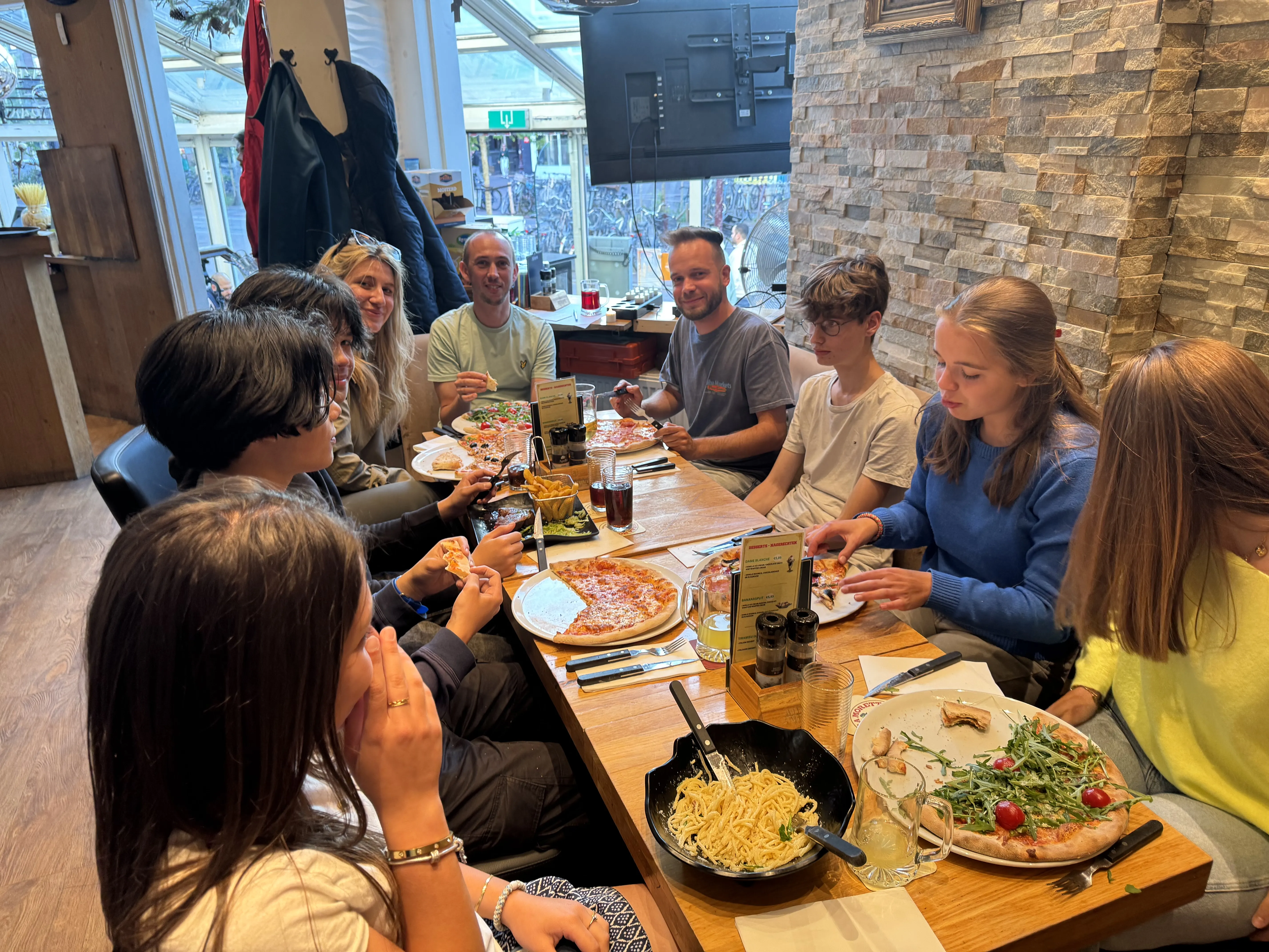 Tafel met pizza, pasta en salade bij Dal Toscano