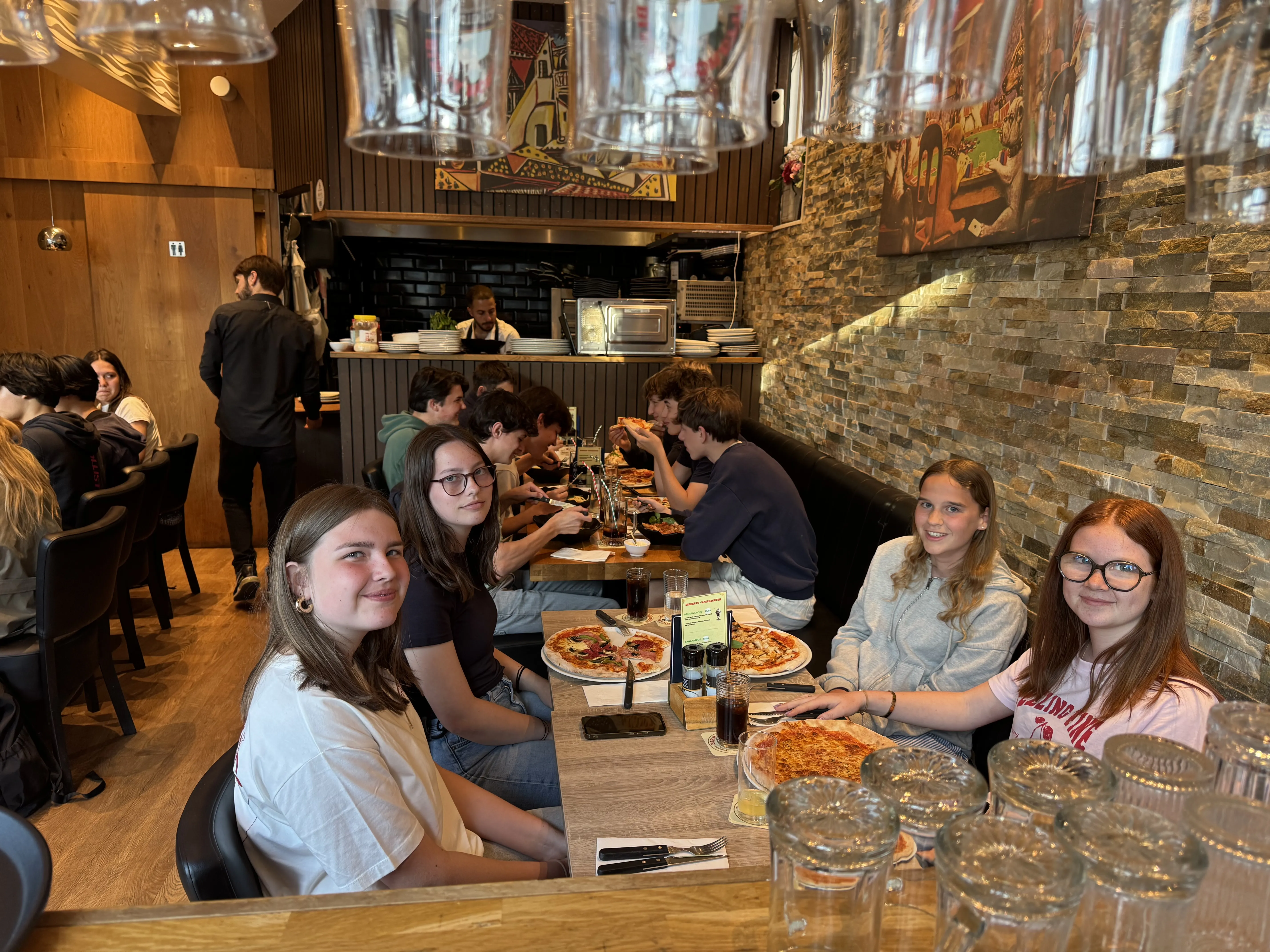 Restaurantzaal met open keuken en pizzabakker aan het werk